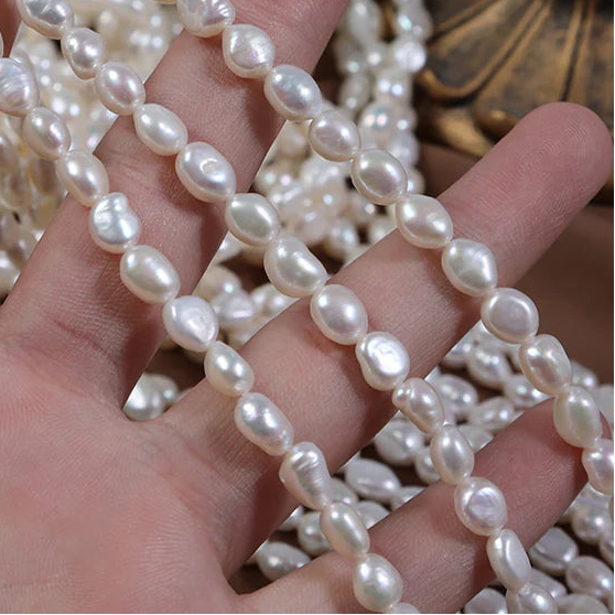 Pearl strand held in a hand with a decorative background